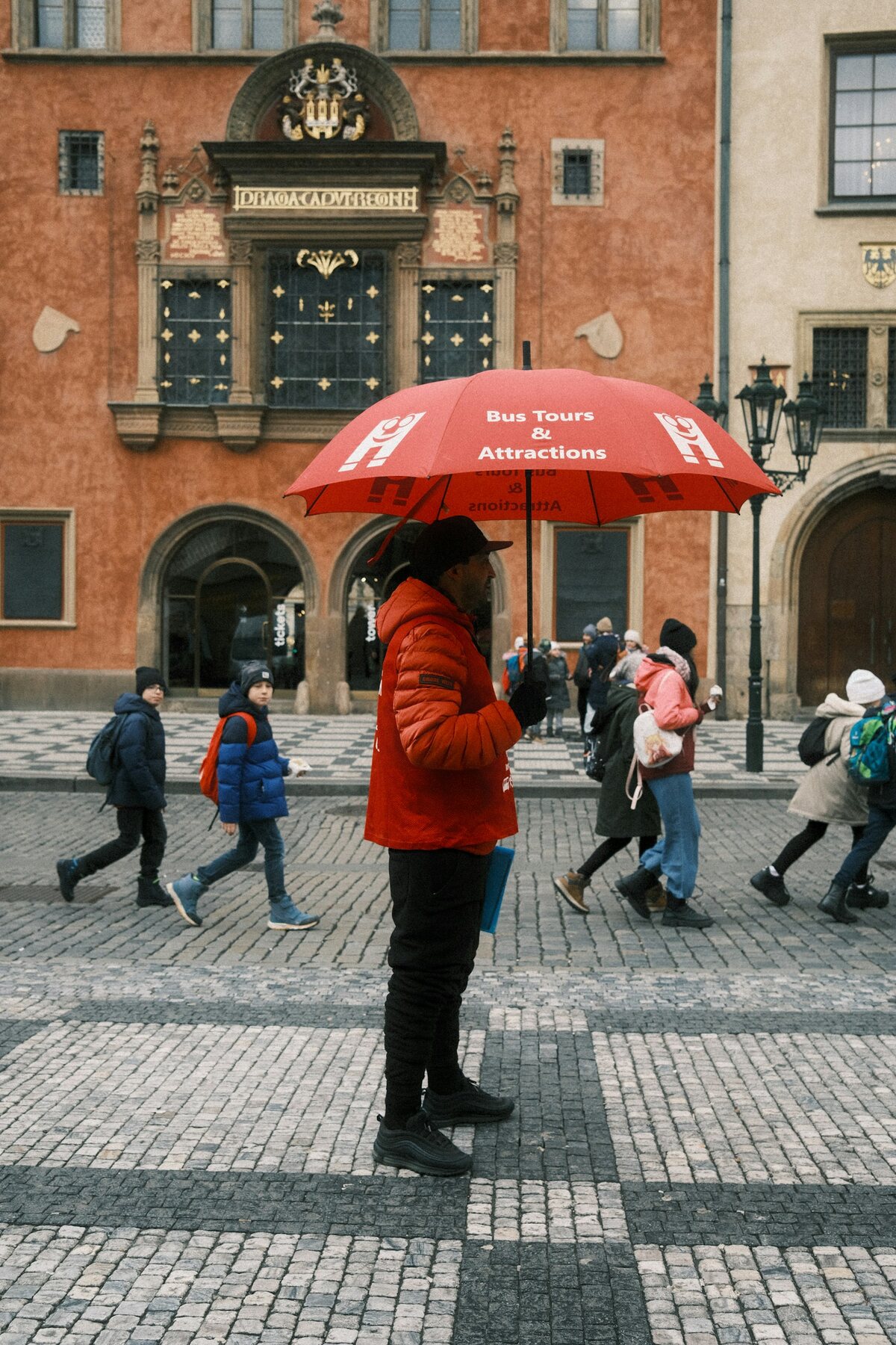 City guide holding a red umbrella ahead of a tour group